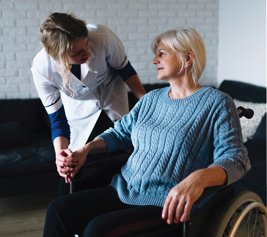 photo of a nurse helping an older woman in a wheelchair.