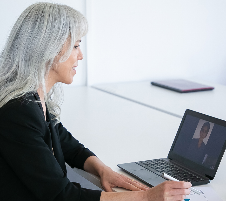 photo of a woman talking to a colleague virtually on her laptop.
