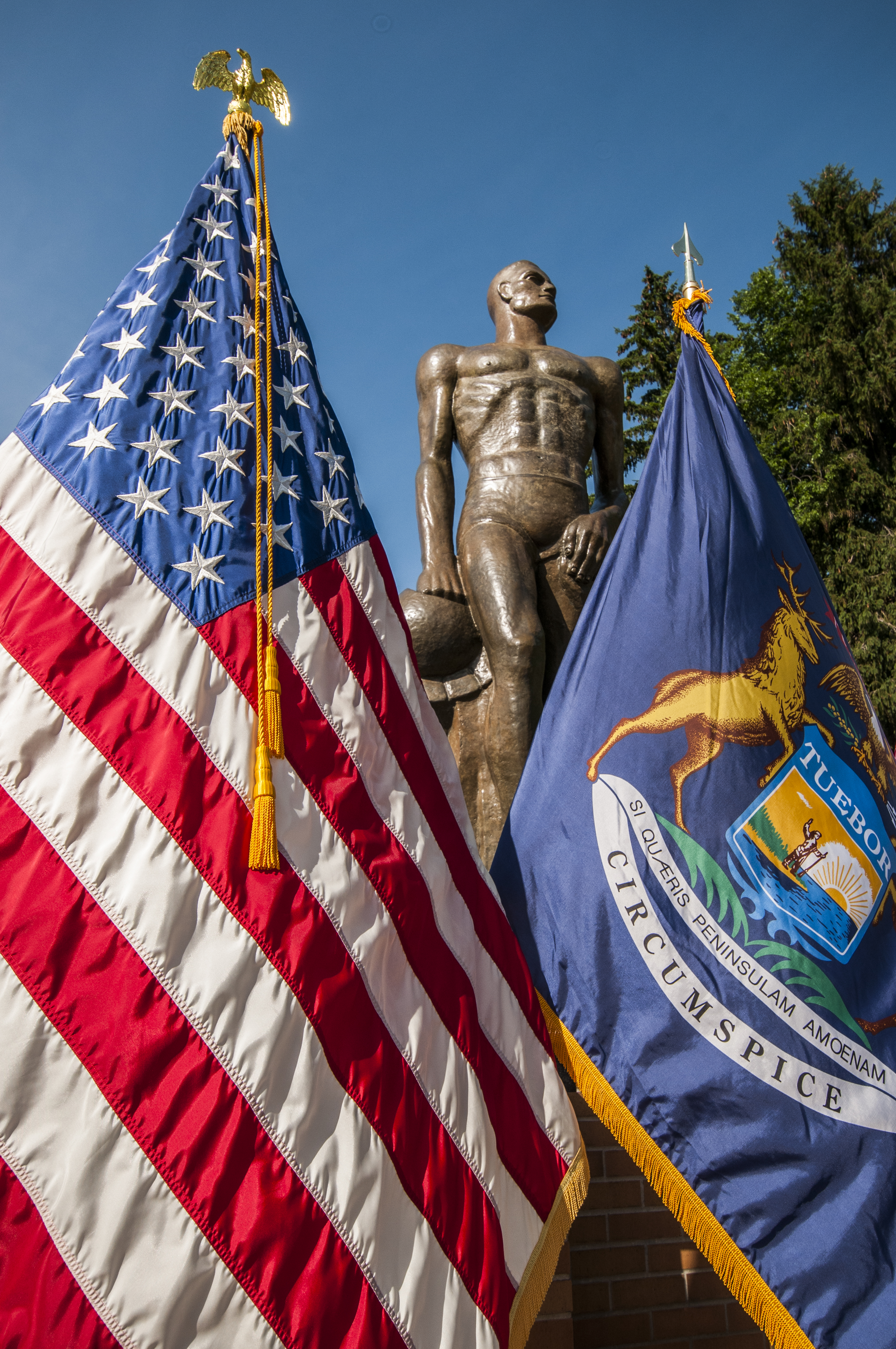 Sparty statue with the US and Michigan flags in front
